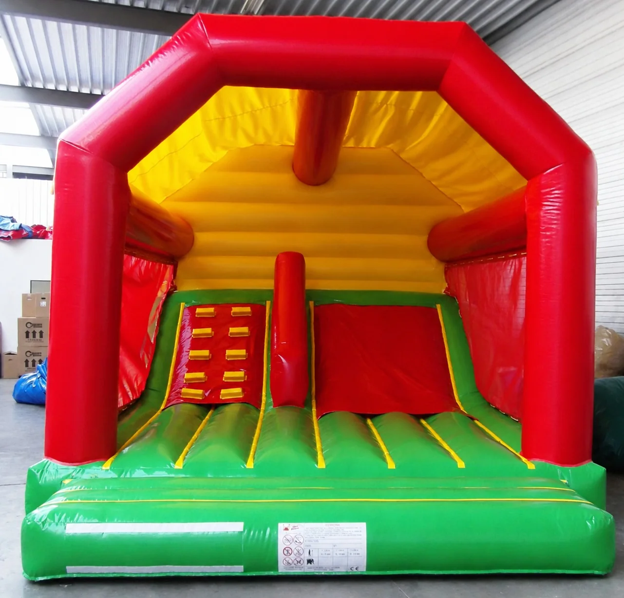 Château classique avec toboggan intérieur rouge, jaune et vert